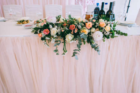 Wedding table decorated with bouquet with roses, eustoma and eucalyptus leaves.の写真素材