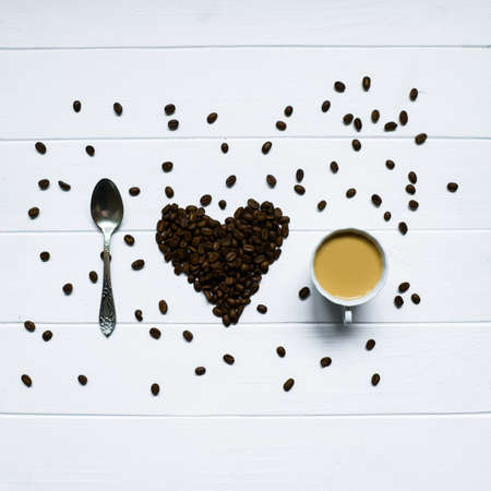 Heart shape made from coffee beans with spoon and cup of coffee, spelling I love coffee.の写真素材