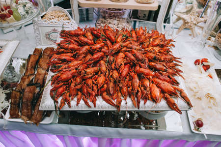 Large square plate of delicious crayfish and lobsters with on the wedding buffet table.の写真素材