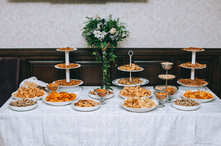 Catering table with salty snacks. Variety of chips, nuts and snacks.の写真素材
