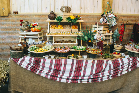 Decorated catering table in the Ukrainian rustic style with different food snacks and appetizers.の写真素材