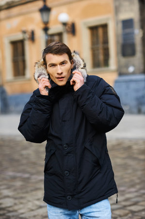 Portrait of a young handsome boy in the winter in the street