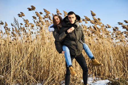happy couple hugging and laughing outdoors in winter.の写真素材
