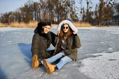 happy couple hugging and laughing outdoors in winterの写真素材