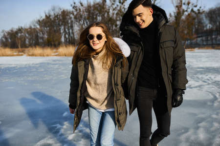 happy couple hugging and laughing outdoors in winterの写真素材