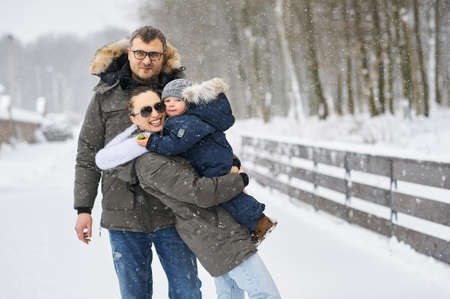 Happy family have a fun outside near the house in winterの写真素材