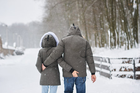 A beautiful young couple in love walking through winter park