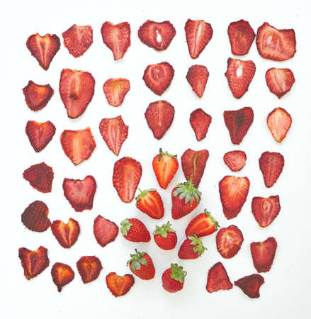 Fresh strawberries and dried strawberries slices on white background.の写真素材