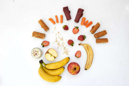 Fresh fruits, pastilles and oatmeal on a white table.の写真素材