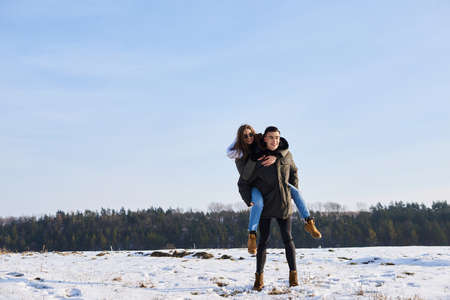 happy couple hugging and laughing outdoors in winter.の写真素材