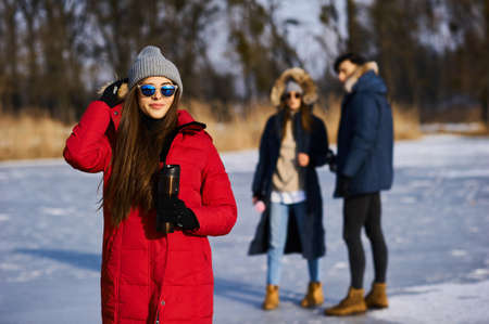 Young friends having fun outdoors in winter time. Concept of friendship and fun with new trendsの写真素材