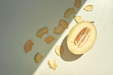 Flat lay composition with fresh and dried melon slices on white table.の写真素材