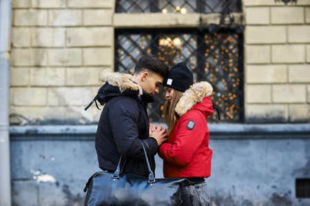 A trendy young couple walks in the city at christmastimeの写真素材