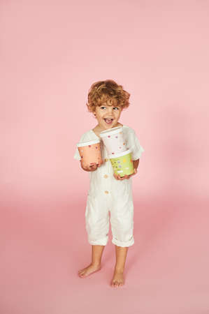 Red-haired boy with colored paper boxes.の写真素材