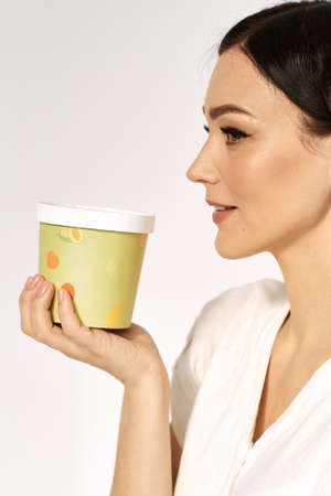 Portrait of a girl with a paper box. Disposable packaging and eco conceptの写真素材