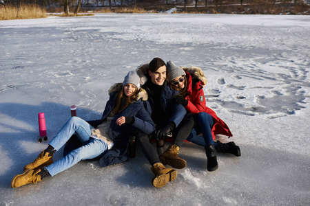 Young friends having fun outdoors in winter time. Concept of friendship and fun with new trendsの写真素材