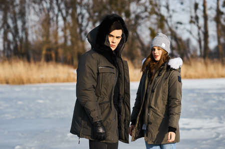 happy couple hugging and laughing outdoors in winterの写真素材