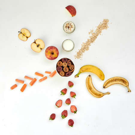 Fresh fruits, pastilles and oatmeal on a white table.の写真素材