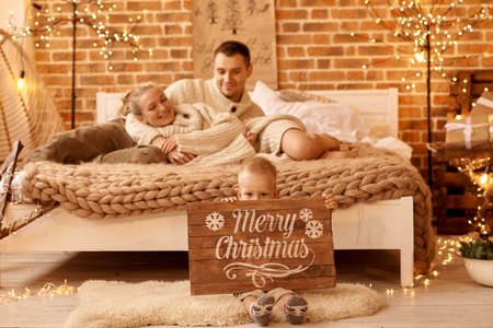 happy family mother father and child on Christmas morning in bedroom playing and have a funの写真素材