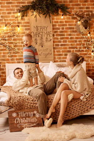 happy family mother father and child on Christmas morning in bedroom playing and have a funの写真素材