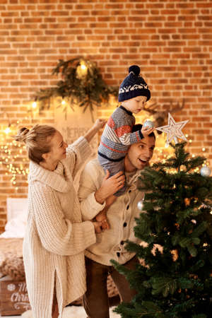 Happy young familyin bedroom decorates the Christmas treeの写真素材