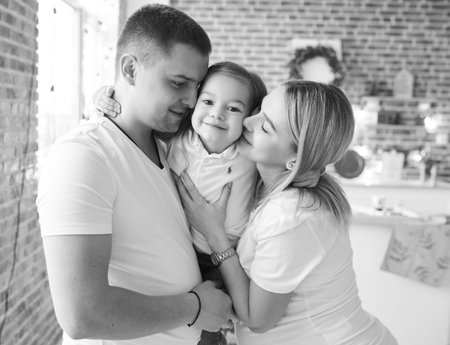Young family, father, pregnant mother and their little daughter have a fun and playing in the...