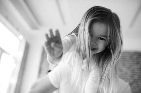 Little daughter with her father have a fun and playing in the kitchen on a brick background with a blurred lightsの写真素材