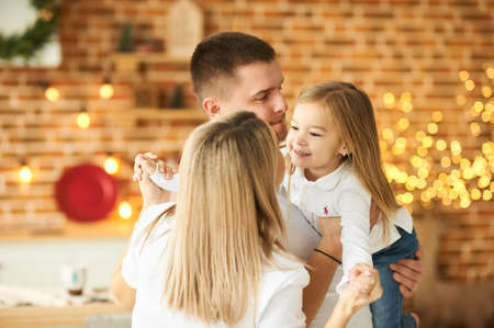 Young family, father, pregnant mother and their little daughter have a fun and playing in the kitchenの写真素材