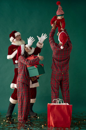 happy family with little child and santa claus on green backgroundの写真素材