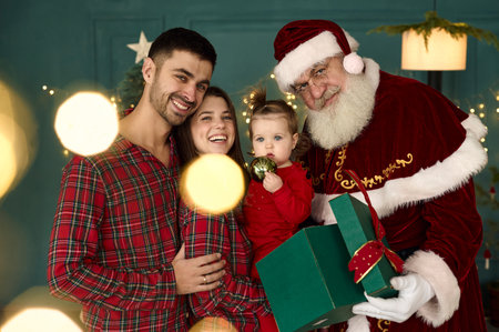 santa and young family at home playing with little baby childの写真素材