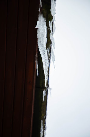 A big beautiful icicle hanging from the roofの写真素材