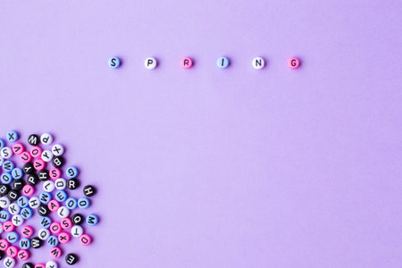 Text spring on english laid out of multi-colored cube on violet backgroundの写真素材