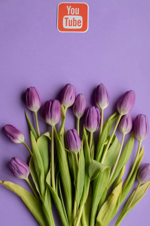 RIGA,LATVIA-APRIL 25,2022.Youtube icon and spring fresh tulips on violet backgroundのeditorial素材