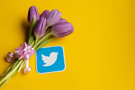 RIGA,LATVIA-APRIL 25,2022.Spring fresh tulips and twitter icon on yellow backgroundのeditorial素材