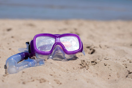 childrens diving mask on the sand at the beachの写真素材