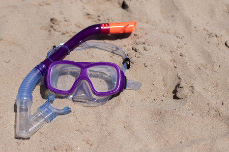 childrens diving mask on the sand at the beachの写真素材