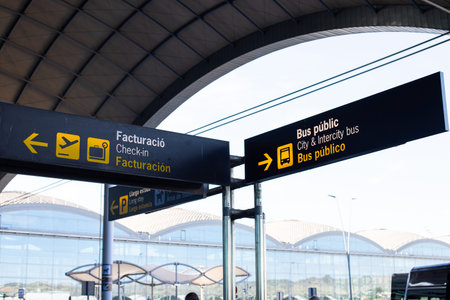 Outdoor airport signs display essential directional information for arriving and departing passengers. Travelers can locate check-in areas for flights and public bus connections for city transport.