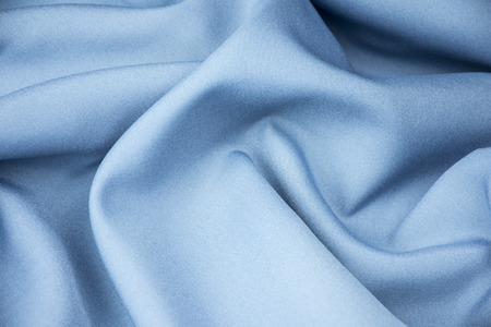 Blue silk fabric is laid out waves for background or texture.の写真素材