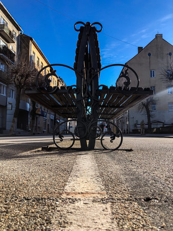 A wooden bench on the street, a bench in the city.