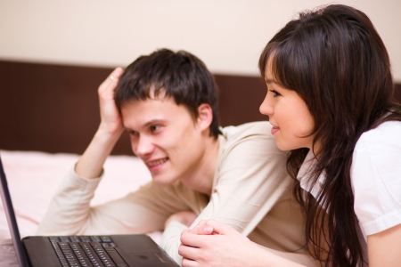 Young couple is playing on laptop, indoor shootの写真素材
