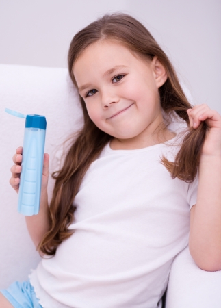 Beautiful girl holding shampooの写真素材