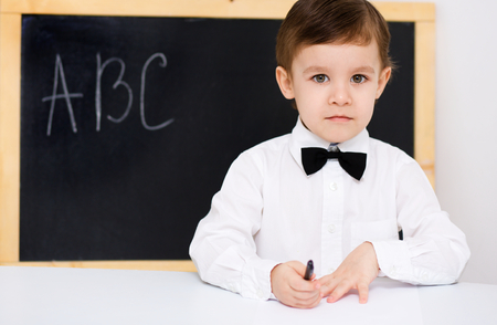 Cute high school student sitting in classroomの写真素材