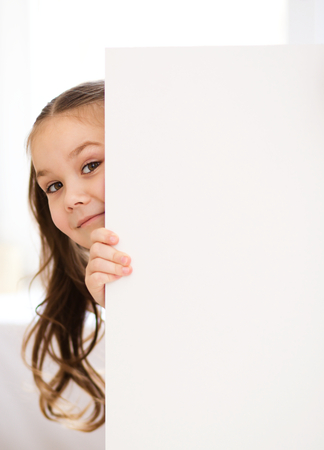 Little girl is holding blank bannerの写真素材