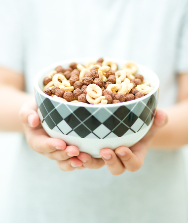 Hands with flakes, bowl of cereal and spoonの写真素材