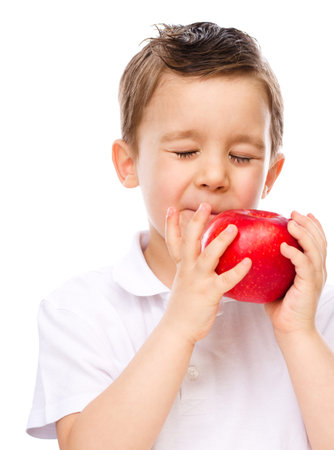 Portrait of a happy little boy with red apples, isolated over whiteの写真素材