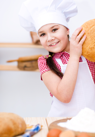 Cute girl making bread in the kitchenの写真素材