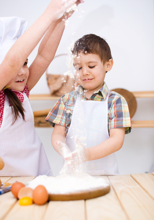 Cute children making bread in the kitchenの写真素材