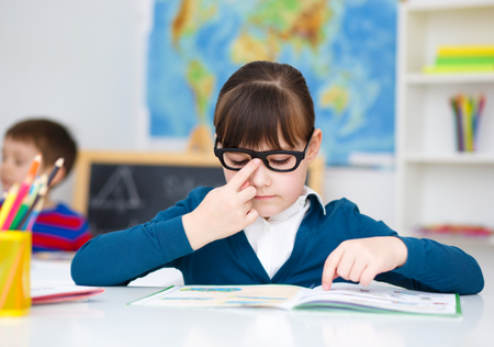 Cute girl is reading book - school, education conceptの写真素材