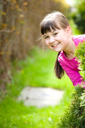 Young cheerful girl is playing outdoorsの写真素材