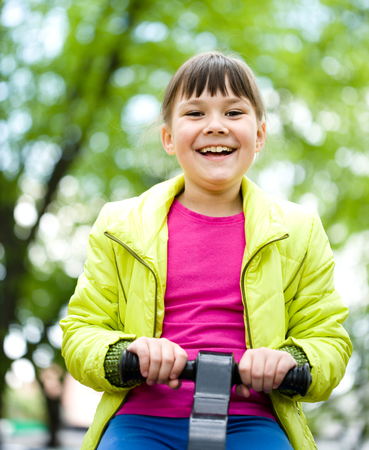 Cute happy girl is playing on playground, outdoorの写真素材
